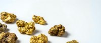 Golden nuggets scattered on white background showing precious metal mining wealth and treasure discovery for investment concepts.