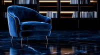 Modern blue velvet armchair with metal legs on dark marble floor, illuminated by dramatic lighting against bookshelf background in luxury interior setting.