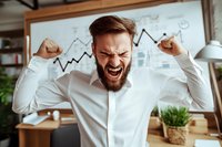 Excited bearded businessman celebrating success with raised fists against growth chart background in modern office. Business achievement concept.
