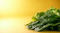 Fresh green spinach leaves on warm golden background for healthy eating and nutrition concepts.