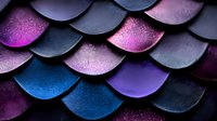 Shimmering mermaid scale pattern in purple, blue and black with metallic texture creates abstract background for fantasy and magical designs.