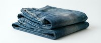 Folded blue denim jeans stacked on white background, casual wear clothing apparel for fashion wardrobe and retail display.