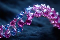 Sparkling crystal bracelet with pink and blue gemstones in spiral pattern on dark background, macro photography showing luxury jewelry details.