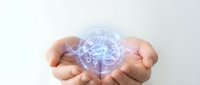 Cupped hands holding glowing digital brain with neural network connections representing artificial intelligence, machine learning and cognitive technology concepts.