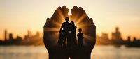 Cupped hands silhouette protecting family of three against golden sunset city skyline. Concept of care, security, insurance and family protection services.