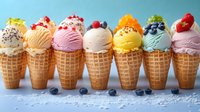Colorful ice cream scoops in waffle cones topped with fresh berries, fruits and sprinkles arranged in row on blue background. Sweet summer dessert variety.