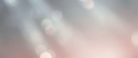 Soft blurred bokeh background with gentle pink and gray tones creating dreamy atmospheric light effects for elegant design projects and presentations.