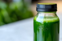 Fresh green vegetable and fruit smoothie in glass bottle with black lid on light background, healthy detox juice drink for wellness and diet.