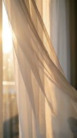 Soft beige curtains flowing gently in warm sunlight creating cozy atmosphere for home interior design and window treatment concepts.