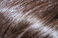 Close-up macro shot of brown animal fur texture showing detailed hair strands and natural pattern. Soft focus creates abstract natural background effect.