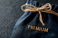 Elegant navy blue fabric gift bag with golden premium text and rustic twine bow on dark background, showcasing luxury branding and packaging design.