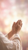 Elderly hands in prayer position against soft bokeh background expressing faith, spirituality and devotion in peaceful meditation moment.