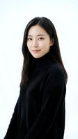 Young Asian woman in black turtleneck sweater smiling confidently on white background, isolated portrait for professional business marketing materials.