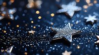 Sparkling silver stars with glitter on dark blue background with golden bokeh lights creating magical festive atmosphere for holiday designs.