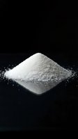 White granulated sugar pile on dark background for culinary and food industry applications.