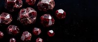 Red garnet gemstones scattered on dark surface with brilliant faceted cuts reflecting light for jewelry design and luxury accessories.