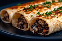 Savory mushroom crepes filled with sauteed wild mushrooms and herbs, garnished with fresh parsley on dark plate, close up view of French cuisine delicacy.