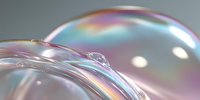 Iridescent soap bubbles with rainbow reflections creating abstract holographic surface patterns on neutral background for modern design projects.