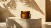 Amber glass cosmetic jar on concrete podium with palm leaves shadow overlay creating minimal luxury spa composition in warm sunlight tones.