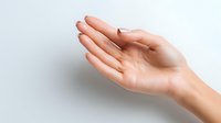 Female hand with open palm gesture against white background, demonstrating presentation or offering position for product placement in advertising.