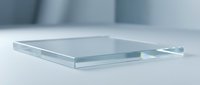 Transparent glass or acrylic square plate on white surface with soft lighting and blurred background for modern minimalist design projects.