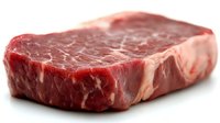 Raw ribeye steak with marbled fat on white background, isolated premium beef cut ready for grilling, cooking and culinary preparation.