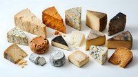 Assorted gourmet cheese collection featuring aged cheddar, blue cheese, brie, gouda and artisanal varieties on white background for culinary design.