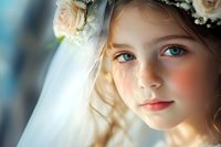 Young girl with blue eyes wearing white floral crown and veil, soft natural lighting creates dreamy atmosphere, gentle smile and freckles, romantic portrait composition.