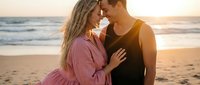 Young couple embracing intimately on beach at golden hour sunset, romantic moment by ocean waves, love and connection concept for lifestyle content.