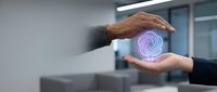 Business professional hands protecting glowing purple spiral hologram in modern office environment representing data security and digital protection.