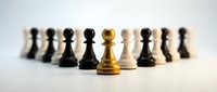Golden chess pawn standing out from crowd of black and white pieces on neutral background. Leadership and uniqueness concept for business strategy.