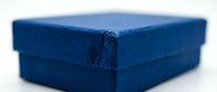 Blue velvet jewelry gift box with lid on white background, elegant packaging for rings, necklaces or bracelets, luxury retail presentation.