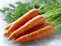 Fresh organic carrots with green tops lying on white surface, macro view showing natural texture and vibrant orange color. For food and healthy lifestyle concepts.