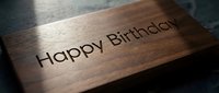 Happy Birthday engraved on wooden plaque with warm lighting, suitable for greeting cards, celebrations, and personalized gift presentations.