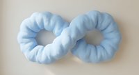 Two soft blue fabric hair scrunchies on neutral background for fashion accessories and hair styling needs.