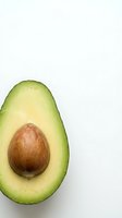 Fresh avocado half with pit on white background isolated for healthy cooking and nutrition content.