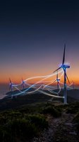 Wind turbines with glowing energy connections at sunset creating sustainable power network on hillside landscape for renewable energy concepts.