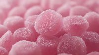 Close-up of pink sugar-coated candy spheres with crystalline texture and sparkle, suitable for confectionery, food, and dessert design projects.