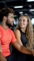 Happy mixed race man and blonde woman embracing in modern gym after workout session. Fitness couple showing affection and motivation in athletic wear.