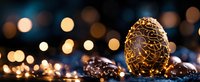 Golden decorative Easter egg with intricate pattern surrounded by chocolate eggs against dark background with glowing bokeh lights creating festive atmosphere.