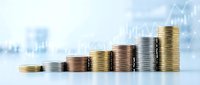 Growing stacks of coins with upward financial chart overlay representing investment growth, profit increase, and economic success in business.