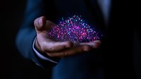 Businessman holding glowing purple and pink particle cloud effect in dark background, representing digital transformation and innovation technology solutions.