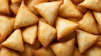 Golden crispy triangular pastries arranged in overlapping pattern, perfect for Middle Eastern cuisine, appetizer menus, and food photography projects.