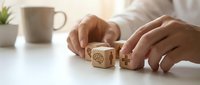 Businessman hands arranging wooden cubes with healthcare medical icons on white desk. Health insurance and medical care concept for business planning.