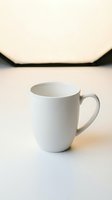 Blank white ceramic mug with handle on neutral background, ready for mockup designs, branding, and product customization projects.
