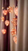 Romantic heart-shaped string lights with warm golden glow creating cozy atmosphere for Valentine's Day celebration and love-themed home decor.