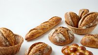 Assorted freshly baked artisan breads including baguettes, rolls, and pretzels arranged in wicker baskets on white background for bakery, food, and culinary use.