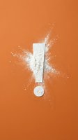 White flour exclamation mark with powder explosion on vibrant orange background for creative design and advertising concepts.