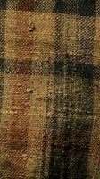 Vintage woven burlap fabric texture with natural hemp fibers in earthy brown and green tones for rustic interior design and craft projects.