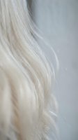 Close-up of flowing platinum blonde hair strands with soft natural texture and movement for beauty and haircare concepts.